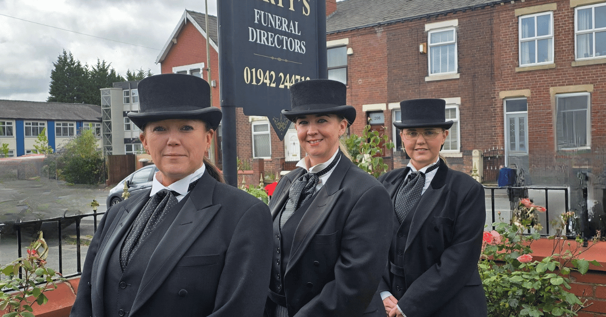 Diane Kristen and Bernadette stood in their uniforms in front of the Varty's sign