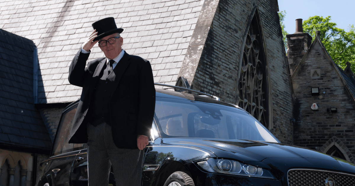 Bill Varty tipping his top hat stood in front of the chapel