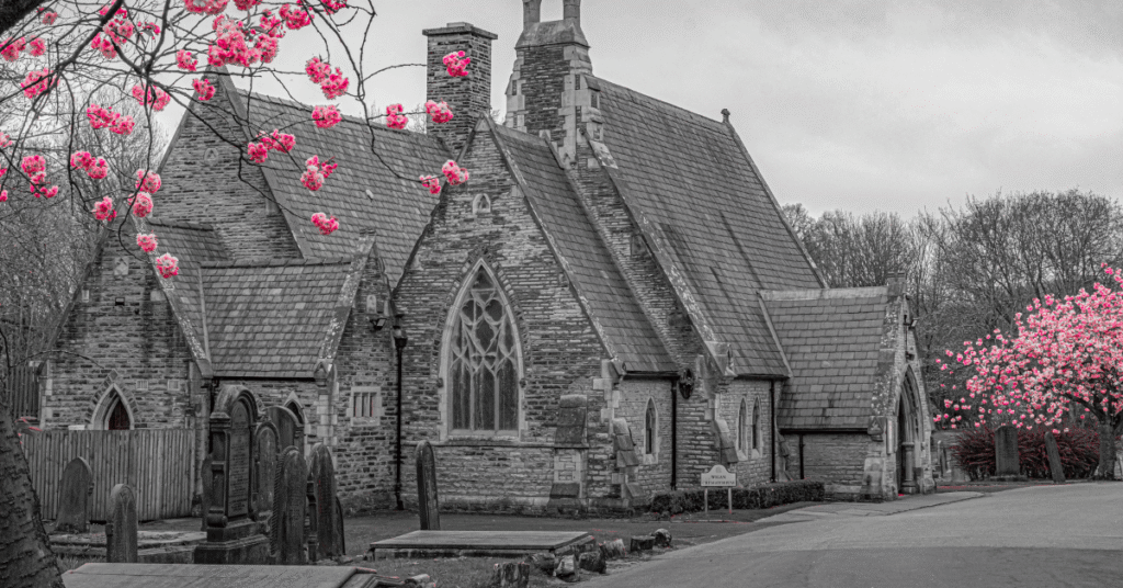 Black and white photo of Wigan Crematorium with pink cherry blossom